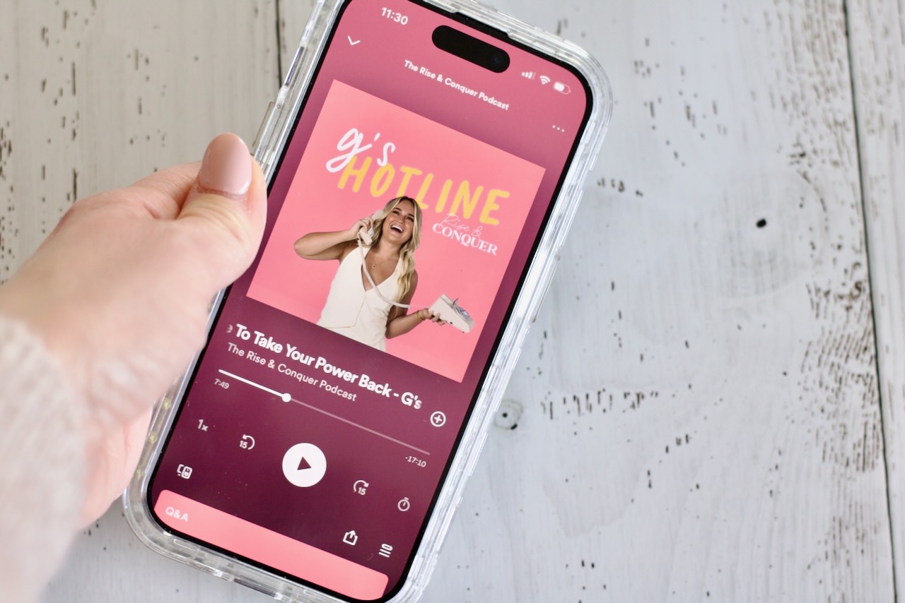 woman holding phone playing podcast