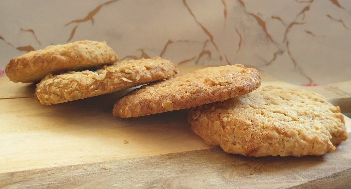 Easy oat cookies layed out on a wooden bread board.