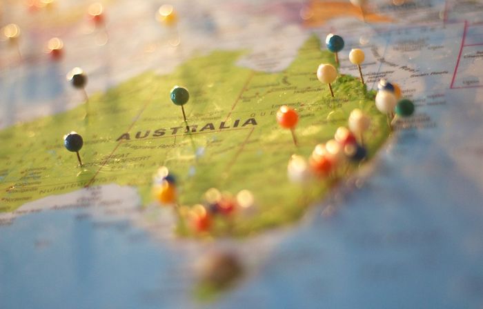 Planning a family holiday to Australia with pins in a map of the country.