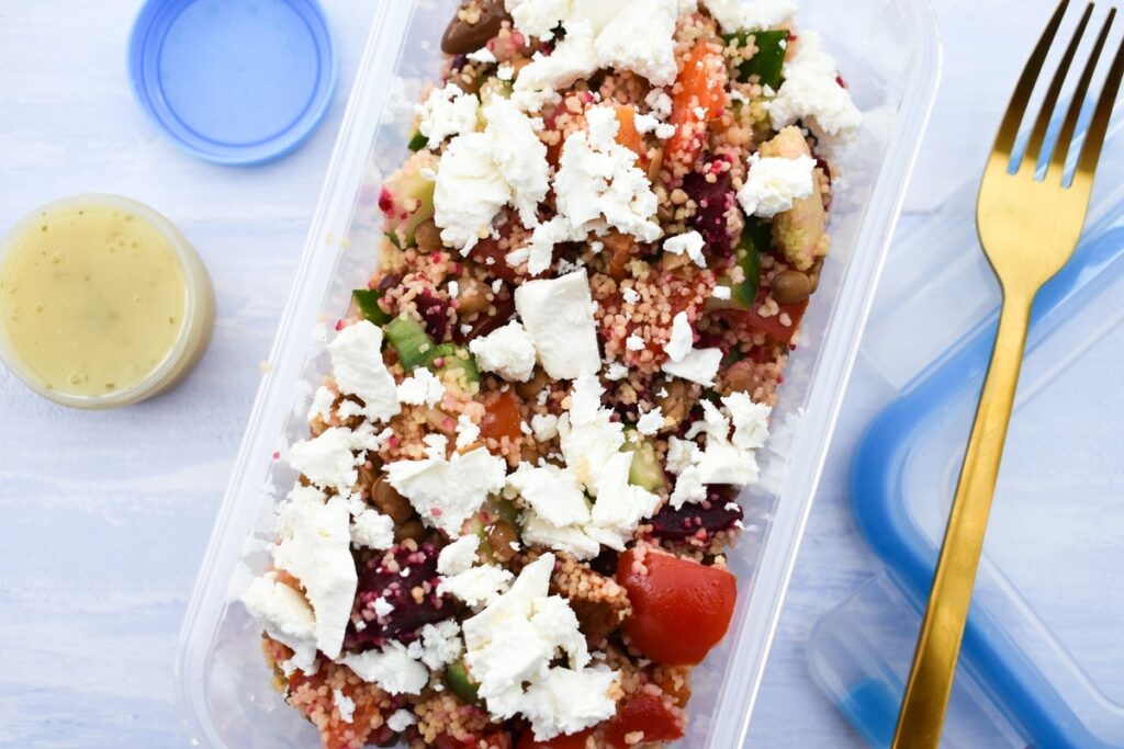 Vegan Lentil Salad in a lunch box topped with crumbled Feta Cheese.